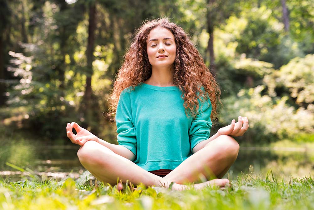 girl meditating with yoga in woods